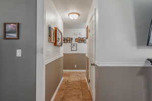 Corridor featuring tile patterned flooring and baseboards