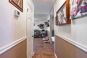 Hallway featuring a textured ceiling