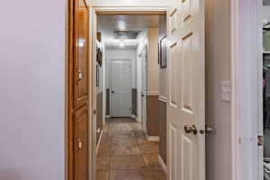 Corridor featuring baseboards and tile patterned floors