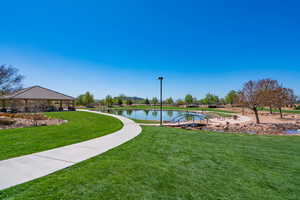 View of community featuring a lawn and a water view