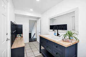 Kitchen featuring wood counters, blue cabinetry, light tile patterned flooring, and recessed lighting