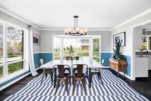 Dining space featuring a chandelier, dark wood-type flooring, and crown molding