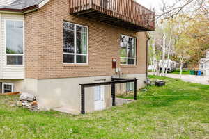 View of east side of property with a lawn and brick siding