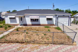 Ranch-style house featuring concrete driveway, an attached garage, a fenced front yard, brick siding, and a shingled roof