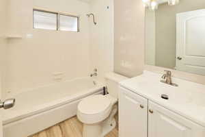 Bathroom with vanity, bathtub / shower combination, and wood finished floors