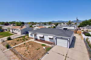 View of front of home with concrete driveway, a residential view, an attached garage, a mountain view, and roof with shingles