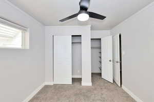Unfurnished bedroom with carpet floors, ornamental molding, and ceiling fan