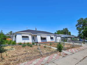 Ranch-style home featuring brick siding, a fenced front yard, roof with shingles, and an attached garage