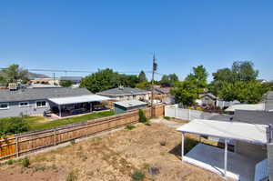 Fenced backyard featuring a residential view and a patio area