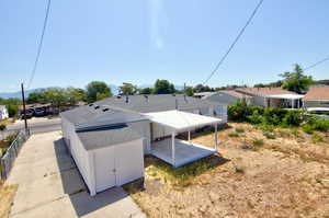 View of side of home with a residential view, a shingled roof, and a mountain view