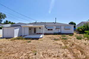Back of property featuring a shed and a wooden deck