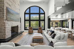 Living room featuring a fireplace, wood finished floors, and a high ceiling