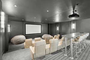 Carpeted cinema room with a bar and recessed lighting