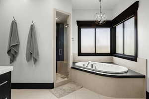 Full bath featuring a bath, a shower stall, tile patterned floors, a chandelier, and vanity