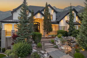 Craftsman inspired home with a standing seam roof, a mountain view, a porch, a shingled roof, and a metal roof