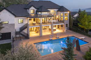 Back of property with a standing seam roof, stairway, a patio, a metal roof, and roof with shingles