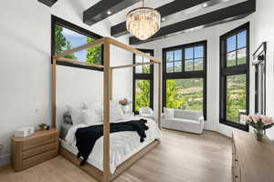 Bedroom featuring a chandelier, light wood-style flooring, a towering ceiling, recessed lighting, and beam ceiling
