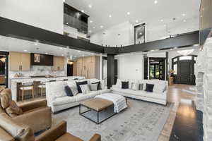 Living area featuring light wood-style flooring, recessed lighting, and a high ceiling