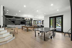 Recreation room featuring recessed lighting, light wood finished floors, billiards table, a chandelier, and french doors