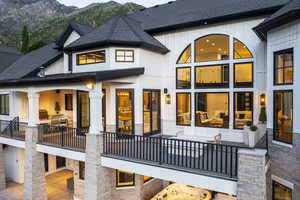 Back of property with a mountain view, a shingled roof, and board and batten siding