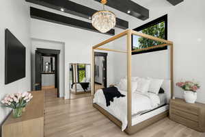 Bedroom with a chandelier, light wood-style floors, and beamed ceiling