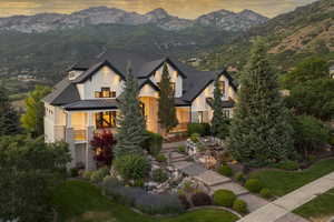 View of front of home featuring a standing seam roof, a mountain view, a metal roof, and stone siding