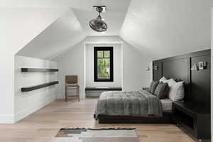 Bedroom with light wood-type flooring and vaulted ceiling