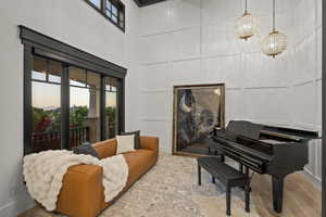 Living area with a decorative wall, a towering ceiling, and wood finished floors