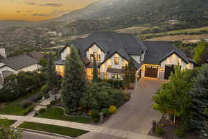 View of front facade featuring an attached garage, a standing seam roof, a mountain view, decorative driveway, and a metal roof