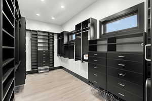 Spacious closet with light wood-style flooring