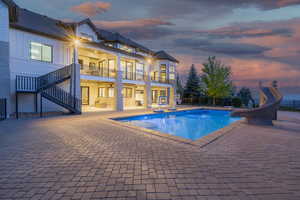 View of pool featuring a water slide, a patio, and stairway