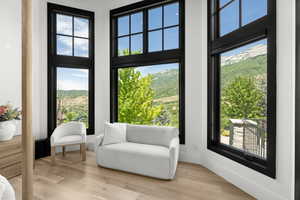 Living area featuring a towering ceiling, light wood finished floors, and a mountain view