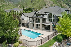Back of property featuring stairway, a fenced backyard, a standing seam roof, and a patio