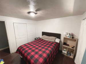 Second upstairs Bedroom featuring a textured ceiling, a closet, and wood finished floors