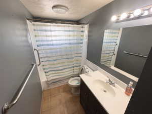 Upstairs Bathroom with a textured ceiling, vanity, and shower / bathtub combination with curtain