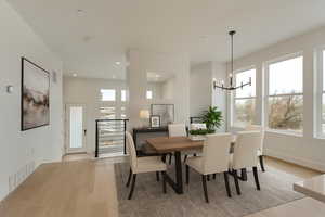 Dining space with light wood-style flooring, a chandelier, and recessed lighting