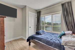 Bedroom with wood finished floors and baseboards