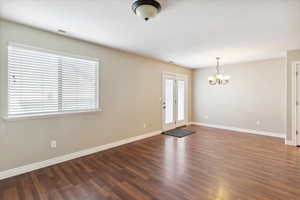 Foyer entrance with a chandelier and wood finished floors
