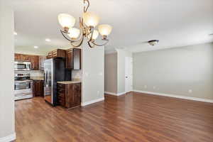 Kitchen with stainless steel appliances, recessed lighting, dark wood-style floors, a chandelier, and open floor plan