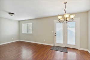 Doorway featuring a chandelier and wood finished floors