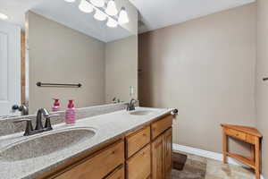 Bathroom with double vanity and baseboards