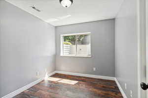 Unfurnished room featuring wood finished floors and baseboards