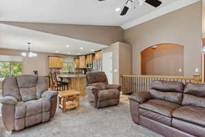Living area featuring a ceiling fan, light colored carpet, a chandelier, plenty of natural light, and recessed lighting