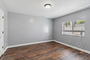 Spare room featuring hardwood / wood-style floors and baseboards