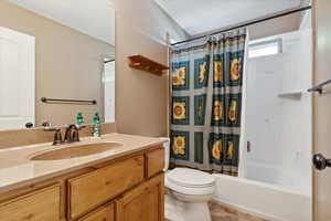 Bathroom featuring vanity, shower / bath combination with curtain, and tile patterned floors