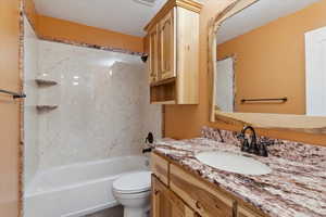 Full bath with vanity, washtub / shower combination, and a textured ceiling