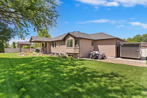 Rear view of house featuring stucco siding and a pergola