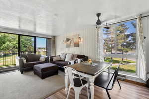 Dining area featuring a textured ceiling, wood finished floors, and wooden walls