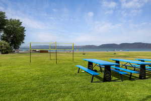 View of home's community with a water and mountain view and a yard