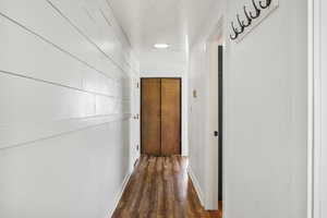 Hall featuring dark wood finished floors and baseboards